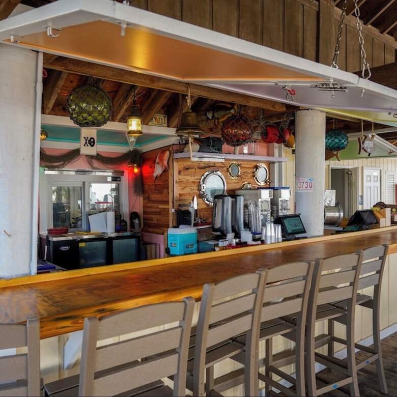 Inside the beach bar at Sandpiper Cove with nautical decor and a long wooden counter