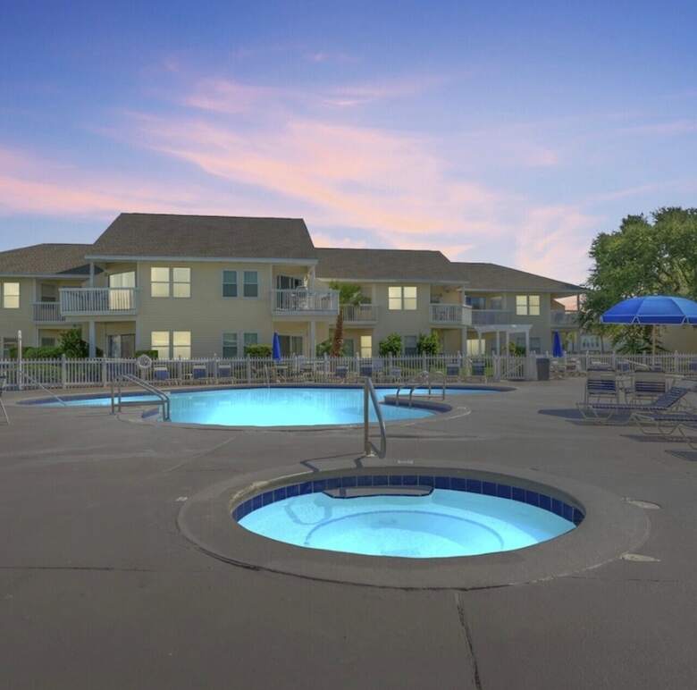 Pool and in-ground hot tub at sunset at Sandpiper Cove